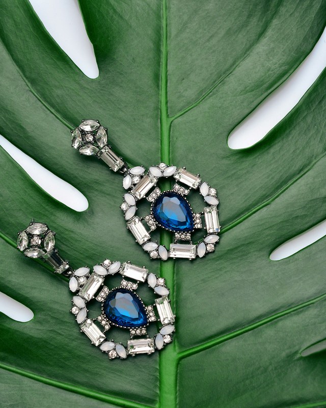 Editorial still life of refined pearl and metal jewellery on silk